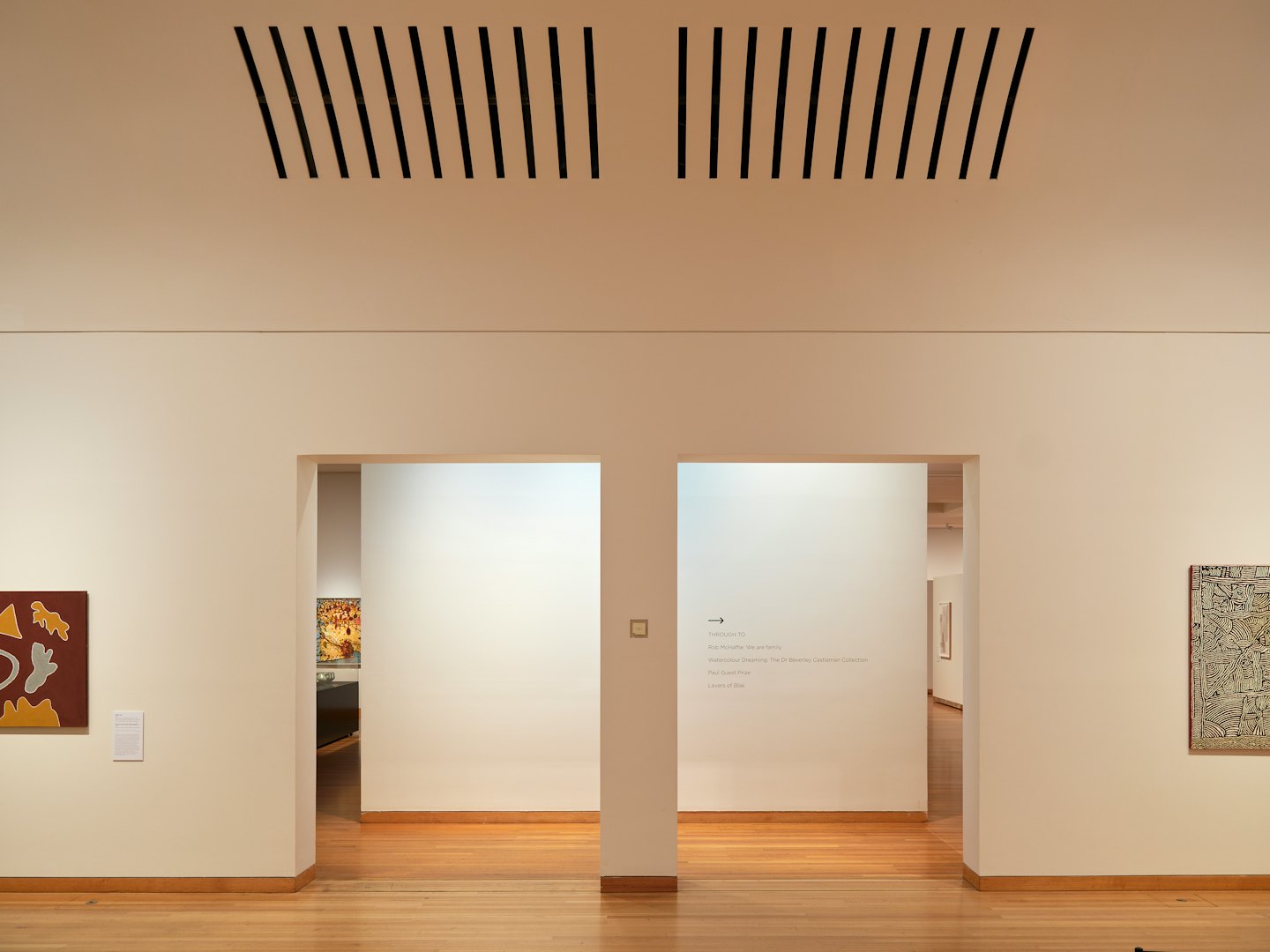 Minimalistische Kunstgalerie mit weißen Wänden und Torbögen.