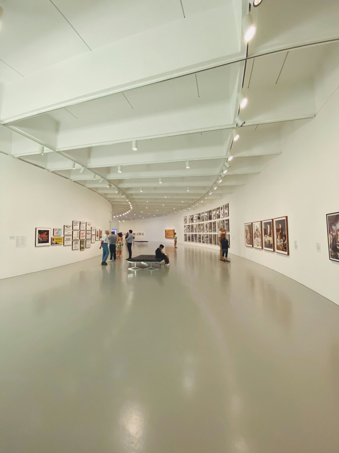 Besucher betrachten Kunst in einer hellen, modernen Galerie.